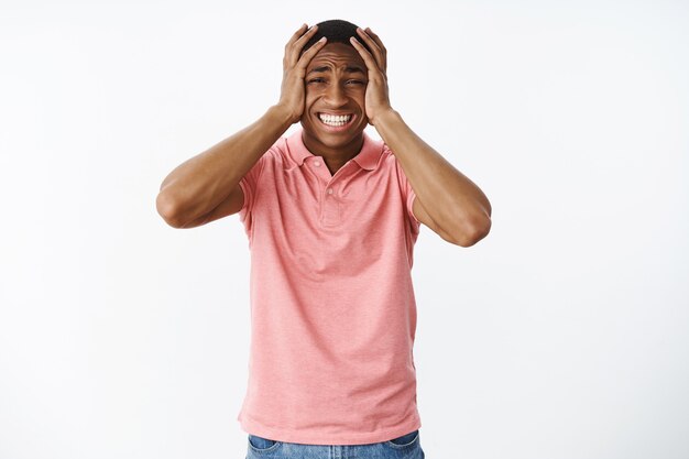 Hübscher junger Afroamerikaner mit rosa Polo-T-Shirt