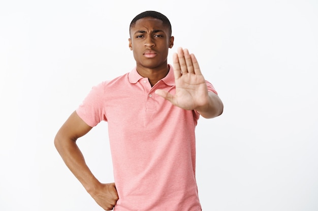 Hübscher junger Afroamerikaner mit rosa Polo-T-Shirt