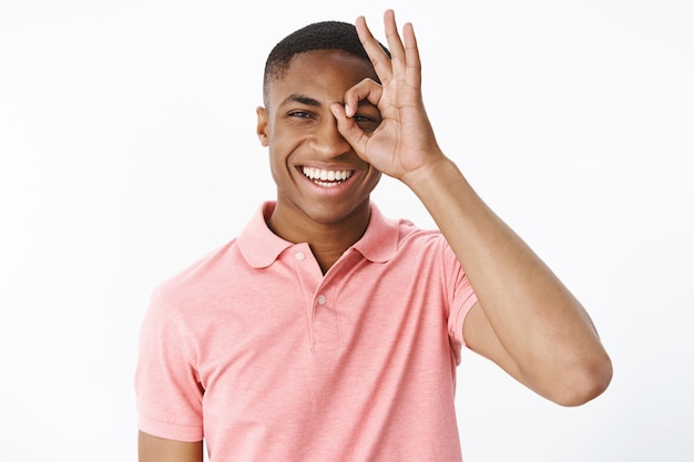 Hübscher junger Afroamerikaner mit rosa Polo-T-Shirt