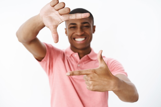 Hübscher junger Afroamerikaner mit rosa Polo-T-Shirt