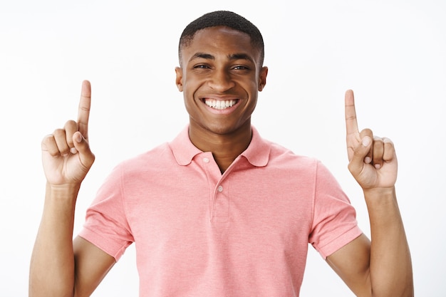 Hübscher junger Afroamerikaner mit rosa Polo-T-Shirt