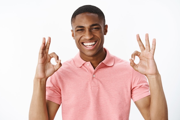 Hübscher junger Afroamerikaner mit rosa Polo-T-Shirt