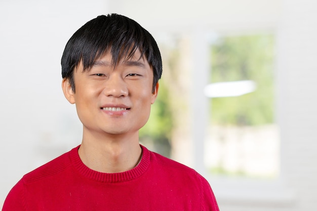 Hübscher junger asiatischer Mann, der lächelt