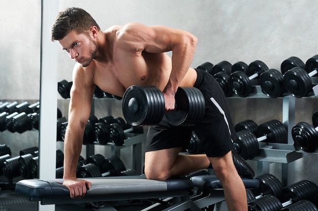 Hübscher junger Athlet, der im Fitnessstudio trainiert