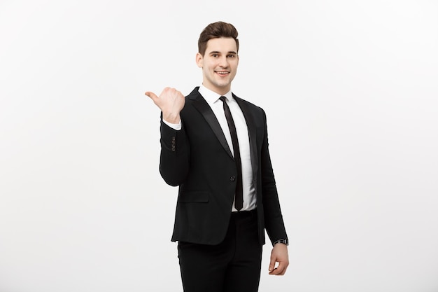 Hübscher junger geschäftsmann glückliches lächeln zeigen finger auf leeren kopienraum, geschäftsmann zeigt zeigende seite, konzept des werbeprodukts, isoliert über weißem hintergrund.