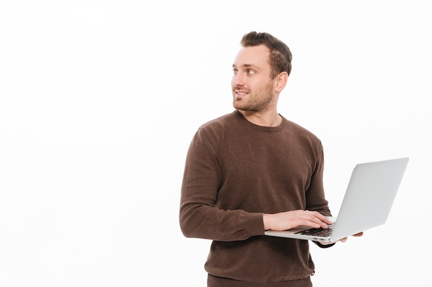 Hübscher junger Mann, der Laptop-Computer verwendet.