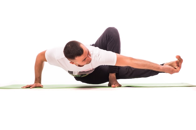 Hübscher junger Mann, der Yoga-Pose lokalisiert auf einem weißen Hintergrund tut