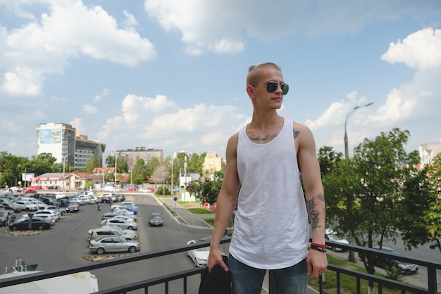 Hübscher Kerl des blonden Mannes des Hippies im stilvollen Sommer kleidet in der Straße