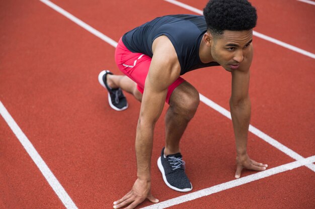 Hübscher konzentrierter afrikanischer Athletenmann, der bereit ist zu beginnen