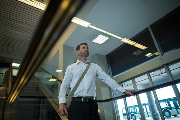 Hübscher Mann auf Rolltreppe