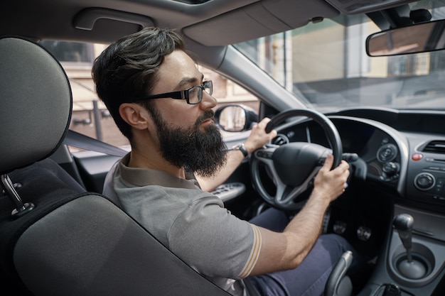 Hübscher Mann, der das Auto fährt