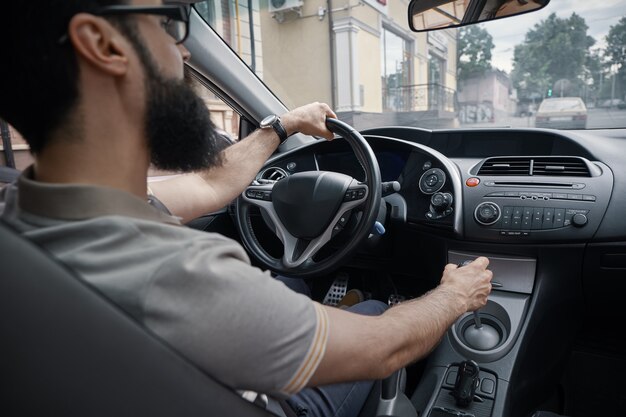 Hübscher Mann, der das Auto fährt