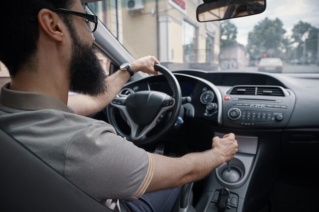 Hübscher Mann, der das Auto fährt