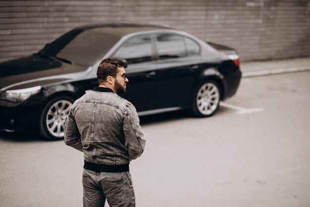 Hübscher Mann, der durch das Auto in der Straße aufwirft