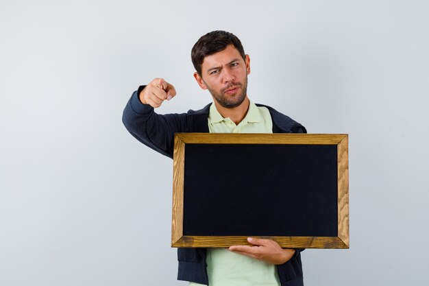 Hübscher Mann, der eine Tafel in einem lässigen Outfit hält