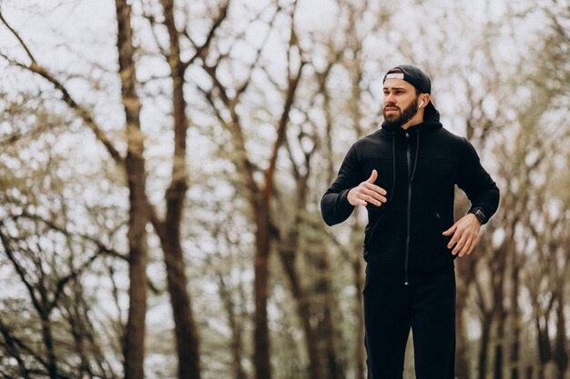 Hübscher Mann, der im Park in Sportkleidung ausübt