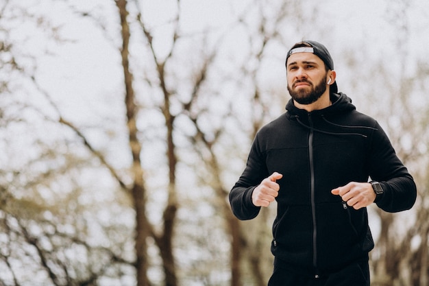 Hübscher Mann, der im Park in Sportkleidung ausübt