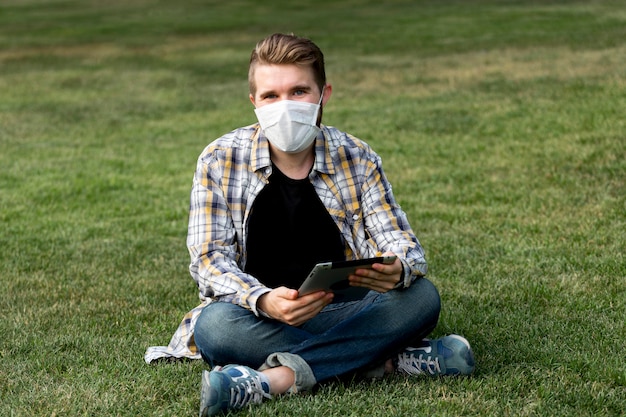 Kostenloses Foto hübscher mann, der mit gesichtsmaske aufwirft