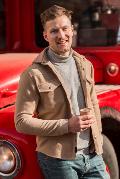 Hübscher Mann, der mit Kaffeetasse aufwirft