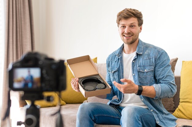 Hübscher Mann, der Unboxing-Video zu Hause aufzeichnet