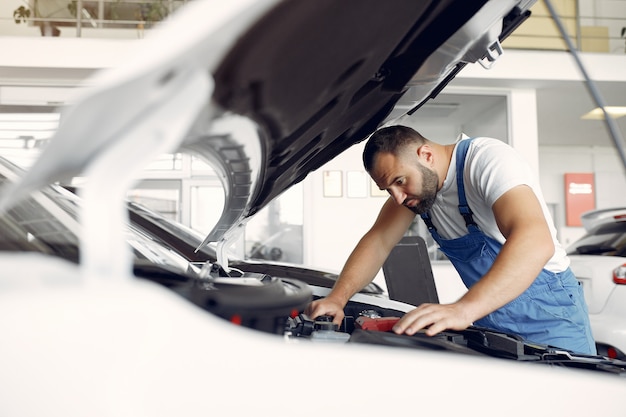 Hübscher Mann in blauer Uniform überprüft das Auto