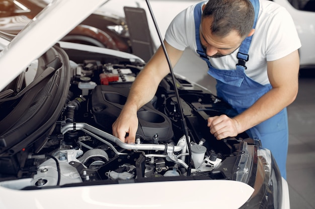 Hübscher Mann in blauer Uniform überprüft das Auto