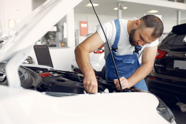 Hübscher Mann in blauer Uniform überprüft das Auto