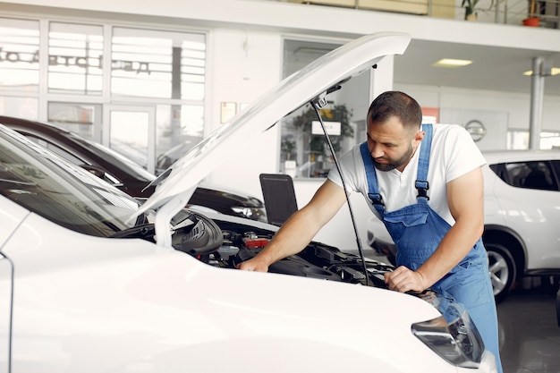 Hübscher Mann in blauer Uniform überprüft das Auto