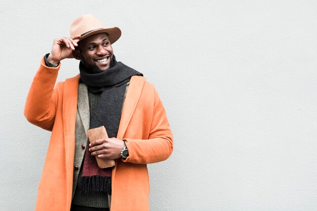 Hübscher Mann in der orange Jacke, die mit Kopienraum aufwirft