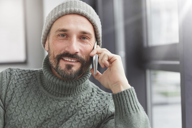 Hübscher Mann mit Bart und Telefon