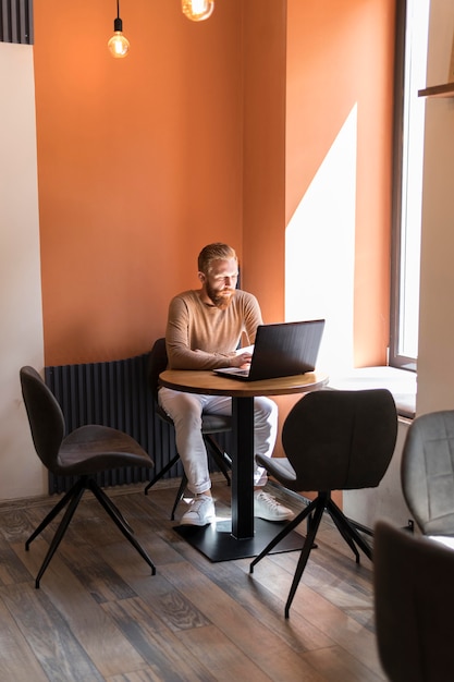 Hübscher moderner Mann, der im Büro arbeitet