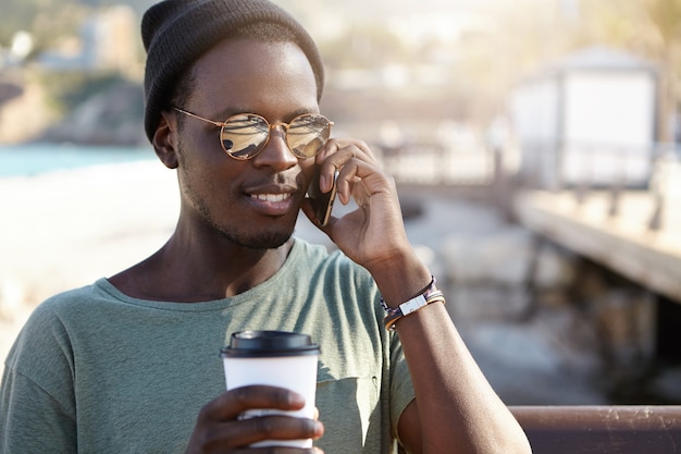 Hübscher modischer hipster, der nette telefongespräche hat