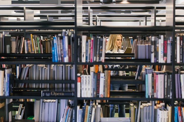 Hübscher Student in Bücherregalen