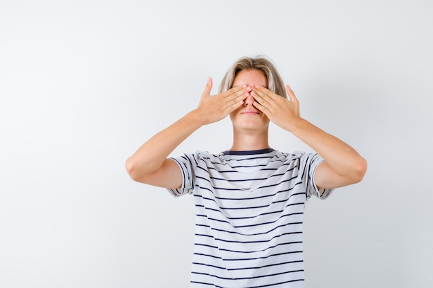 Kostenloses Foto hübscher teenager in einem gestreiften t-shirt, das seine augen bedeckt