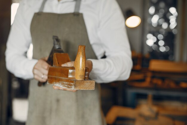 Hübscher Tischler, der mit einem Holz arbeitet