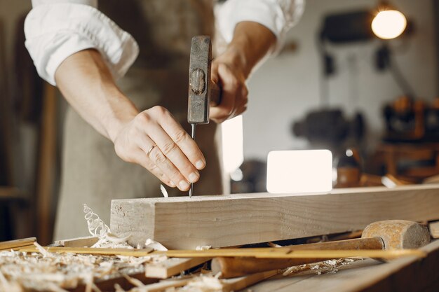 Hübscher Tischler, der mit einem Holz arbeitet