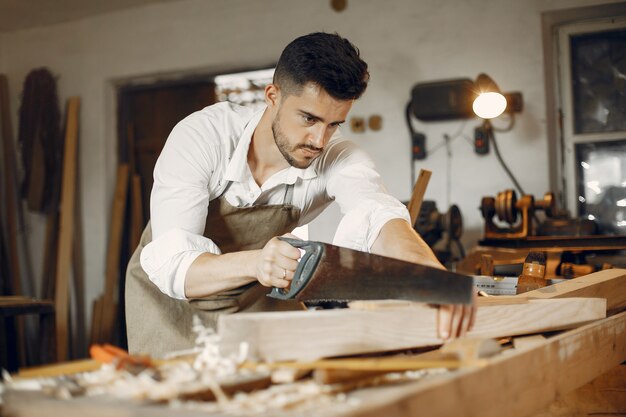 Hübscher Tischler, der mit einem Holz arbeitet