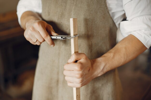 Hübscher Tischler, der mit einem Holz arbeitet