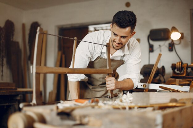 Hübscher Tischler, der mit einem Holz arbeitet