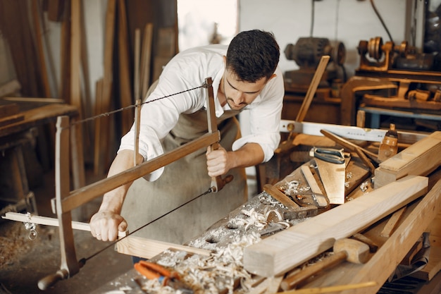 Kostenloses Foto hübscher tischler, der mit einem holz arbeitet