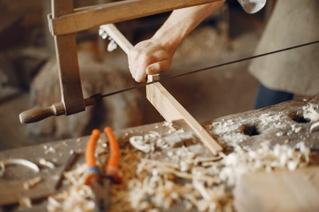 Hübscher Tischler, der mit einem Holz arbeitet