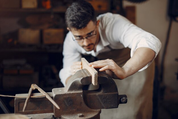 Hübscher Tischler, der mit einem Holz arbeitet