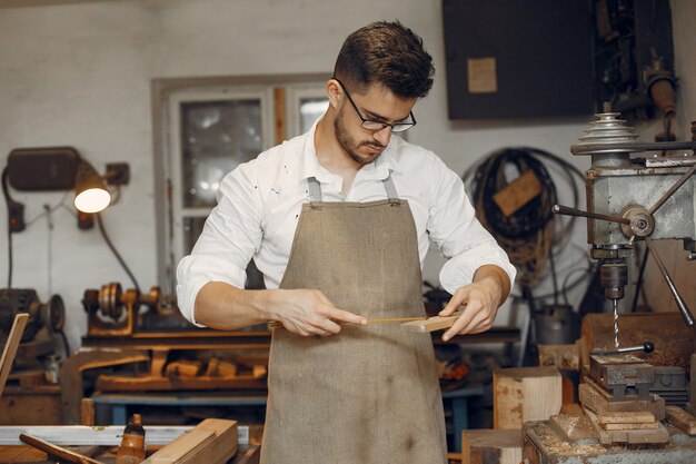 Hübscher Tischler, der mit einem Holz arbeitet