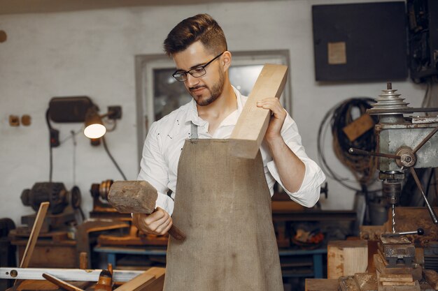 Hübscher Tischler, der mit einem Holz arbeitet