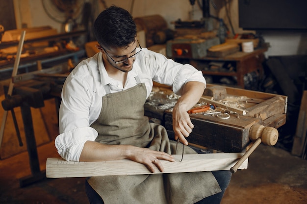 Hübscher Tischler, der mit einem Holz arbeitet