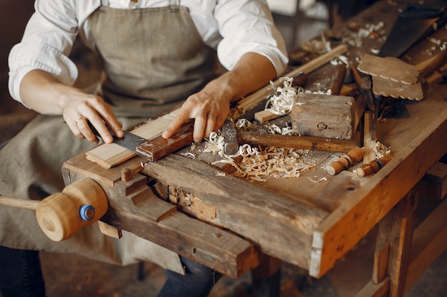 Kostenloses Foto hübscher tischler, der mit einem holz arbeitet