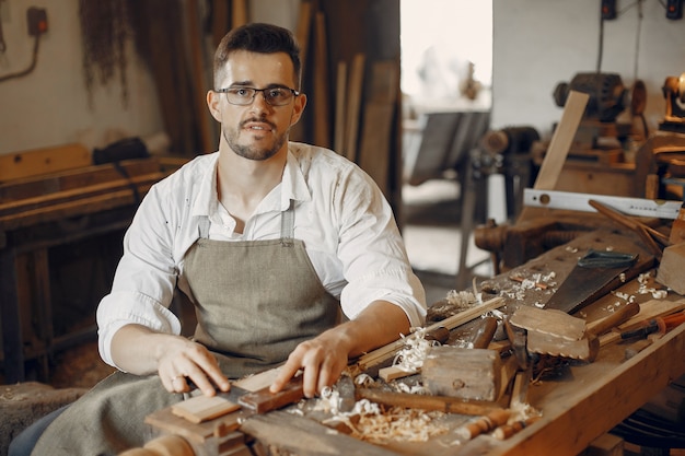 Hübscher Tischler, der mit einem Holz arbeitet