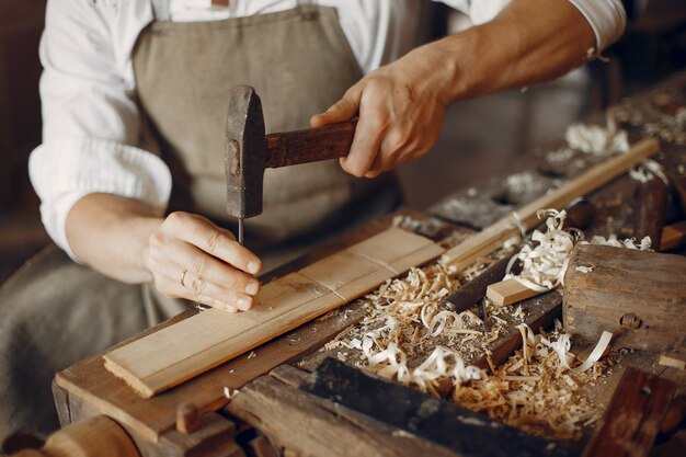 Hübscher Tischler, der mit einem Holz arbeitet