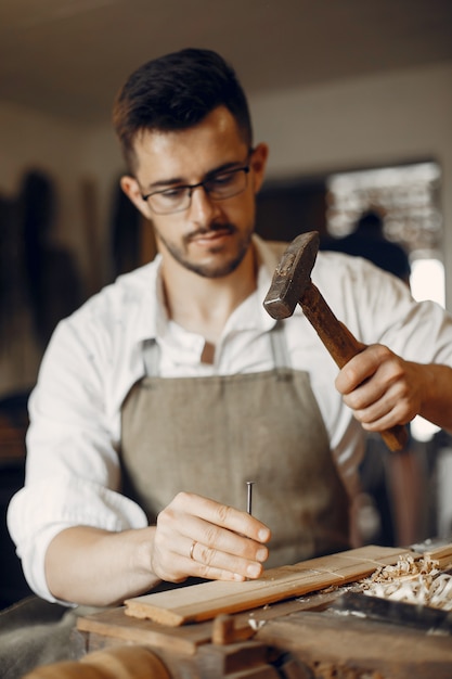 Hübscher Tischler, der mit einem Holz arbeitet