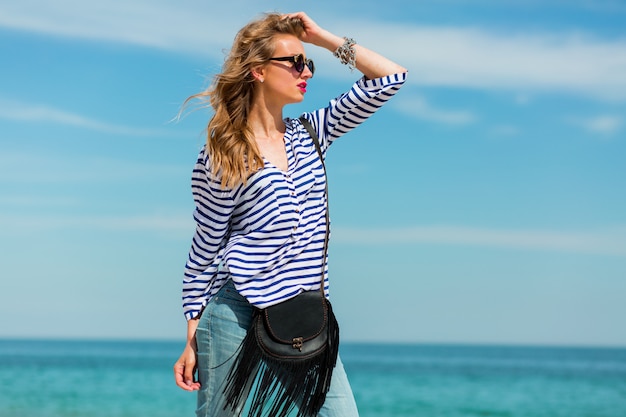 Hübsches Glück junge Frau, die lacht und Spaß am sonnigen Strand hat